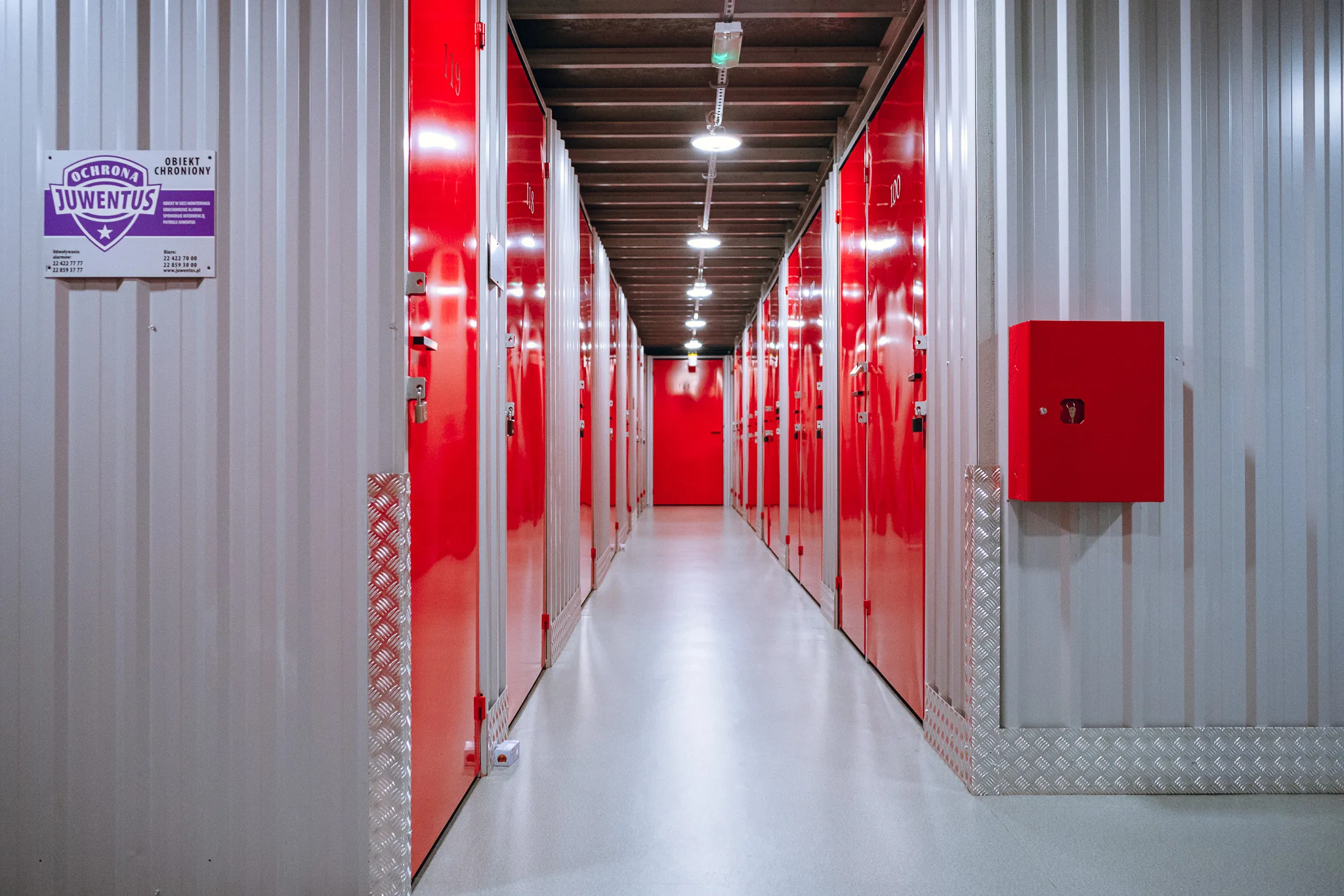 Korytarz z naklejką ochrony i sprzętem przeciwpożarowym w Celtic Self Storage Piaseczno